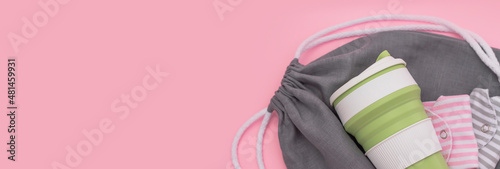 Trendy environmental friendly reusable cup. Folded reusable cotton menstrual pads. Grey shopping mesh bag. Concept of conscious consumption. Alternatives to disposables banner