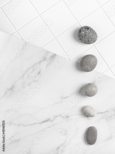 Minimalistic creative background with light marble and tiles texture and stones pattern. Flatlay display for cosmetic products, top view, copy space.