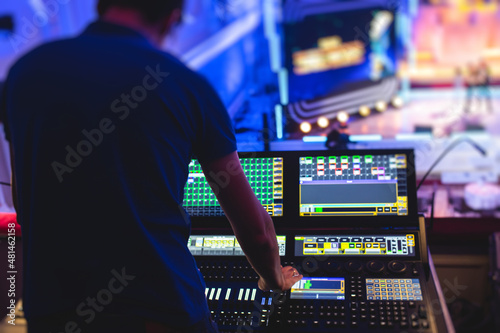 Foto View of lighting technician operator working on mixing console workplace during