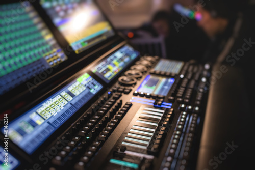 View of lighting technician operator working on mixing console workplace during live event concert on stage show broadcast, light mixer controller panel, sound technician with professional equipment