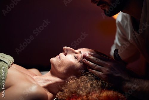 Woman on a massaging, chiropracting table, treatment of body and face skin tension.