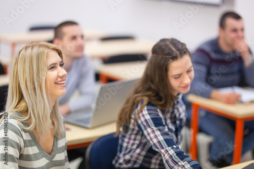 Young student in modern classroom listening to lecture.