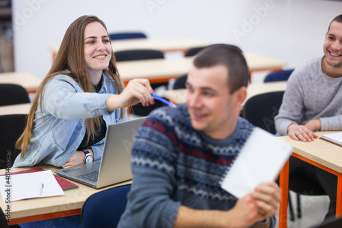 Students teasing each other having fun during class in a modern classroom..