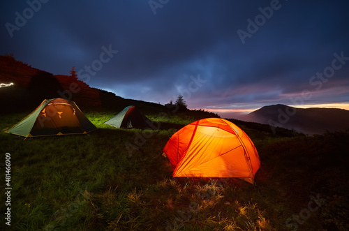 Fototapeta Naklejka Na Ścianę i Meble -  Illuminated orange camping tent under moon
