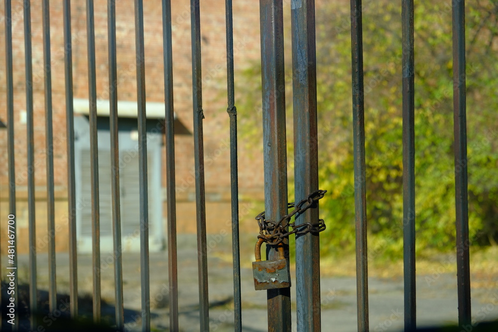 The old gates of the factory are locked with a rusty old chain around