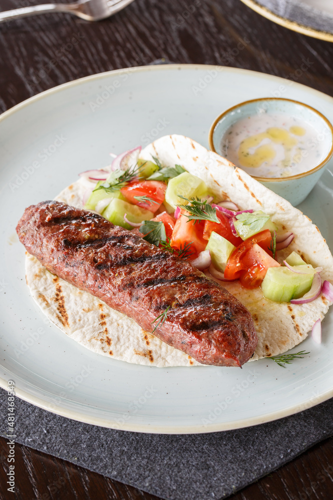 Fried lula kebab of minced beef with pistachios. Served with flatbread, salad and white sauce. Fried lula kebab of minced beef with pistachios. Served with flatbread, salad and white sauce.
