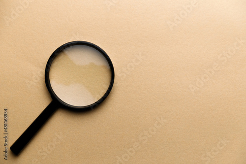 a golden magnifier on yellow paper background