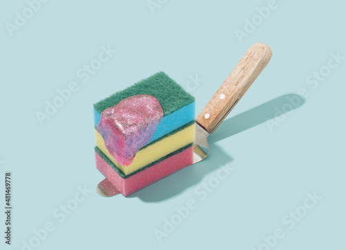 Cake spatula with colorful sponges and pink slime on a pastel blue background. Future past retro concept.