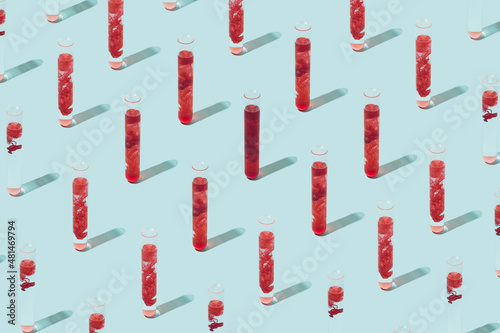 Test tubes with various amount of blood inside on a light blue background. Laboratory analysis minimal concept. photo