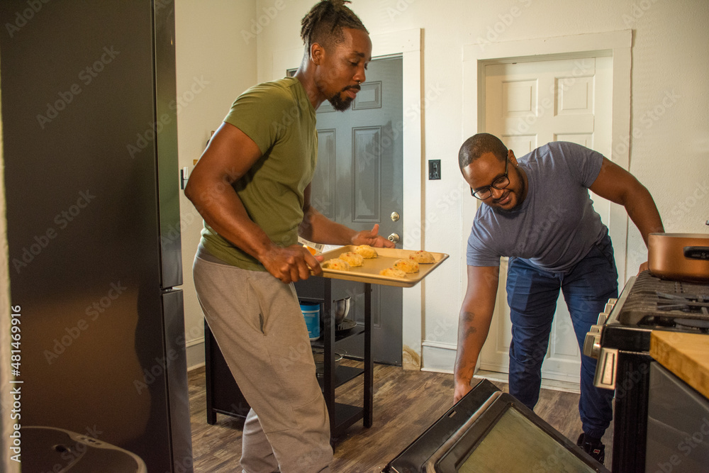 Male couple baking in kitchen Male couple baking in kitchen