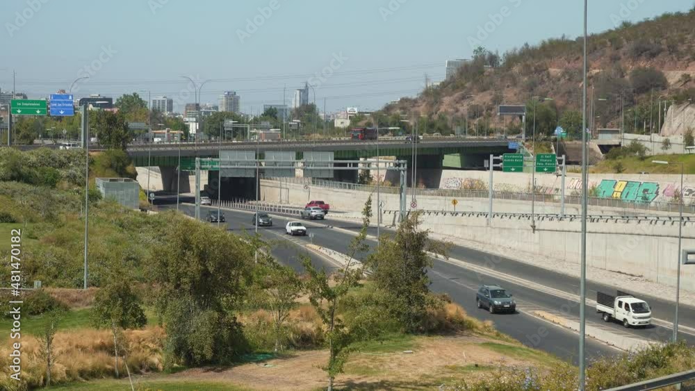 Commuter cars driving in busy Costanera Sur Avenue near hillside at daytime, Santiago, Chile Commuter cars driving in busy Costanera Sur Avenue near hillside at daytime, Santiago, Chile