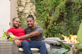 Smiling male couple sitting by fire pit