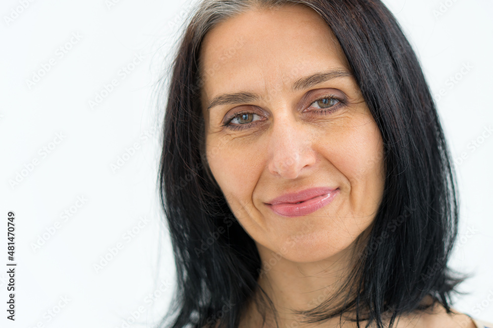 Close-up portrait of middle aged woman starting getting grey-haired on white background, face skin care beauty, middle age skincare cosmetics, cosmetology concept. Close-up portrait of middle aged woman starting getting grey-haired on white background, face skin care beauty, middle age skincare cosmetics, cosmetology concept.