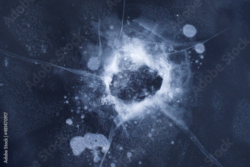 Cuadro en lienzo Cracks and air in the ice around a frozen hole in the surface of a river