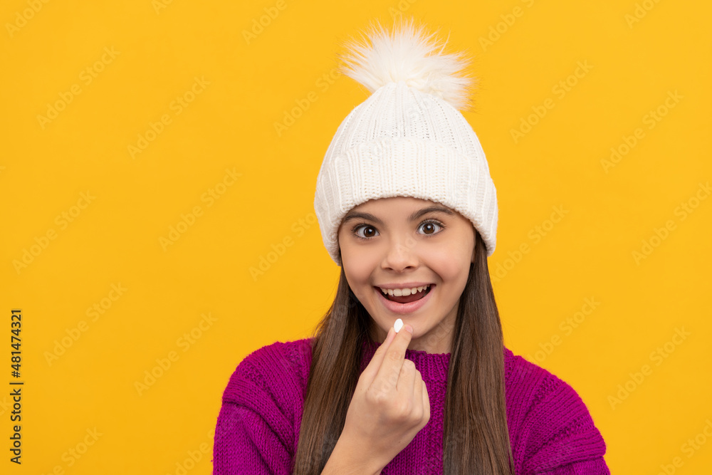 childhood health. child in winter hat taking pill. food supplement. childhood health. child in winter hat taking pill. food supplement.