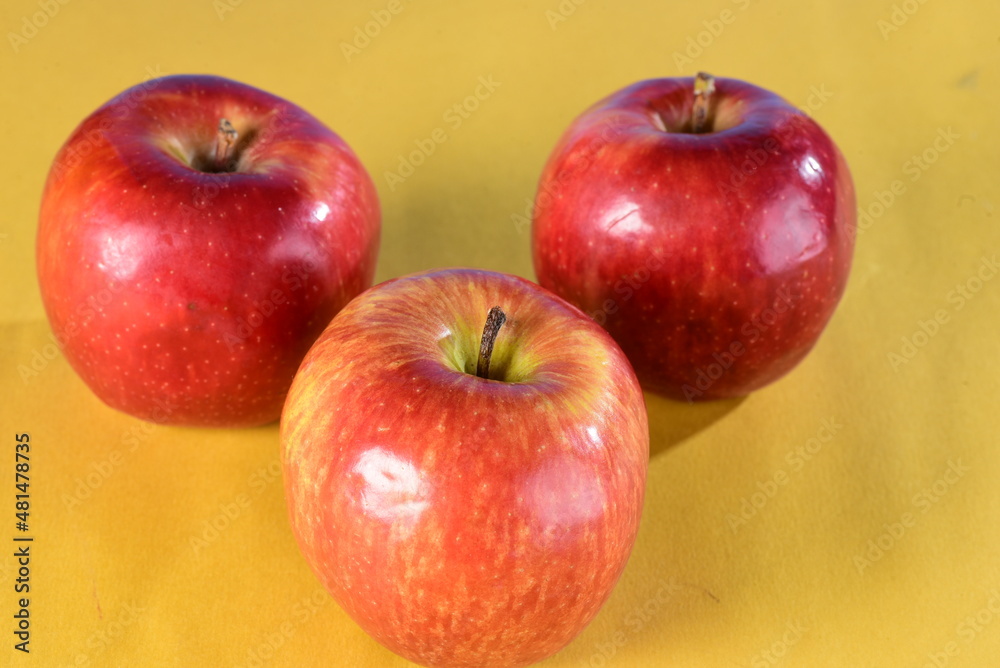 beautiful red apples seen from the side isolated on yellow and blue background, healthy natural fruit beautiful red apples seen from the side isolated on yellow and blue background, healthy natural fruit