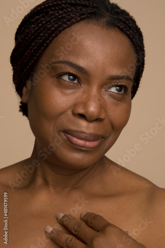Studio portrait of smiling mature woman with braided hair