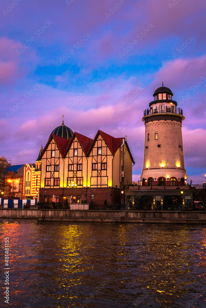 Fishing village in Kaliningrad at night. Stylization of ancient Europe, lighthouse, ancient houses.