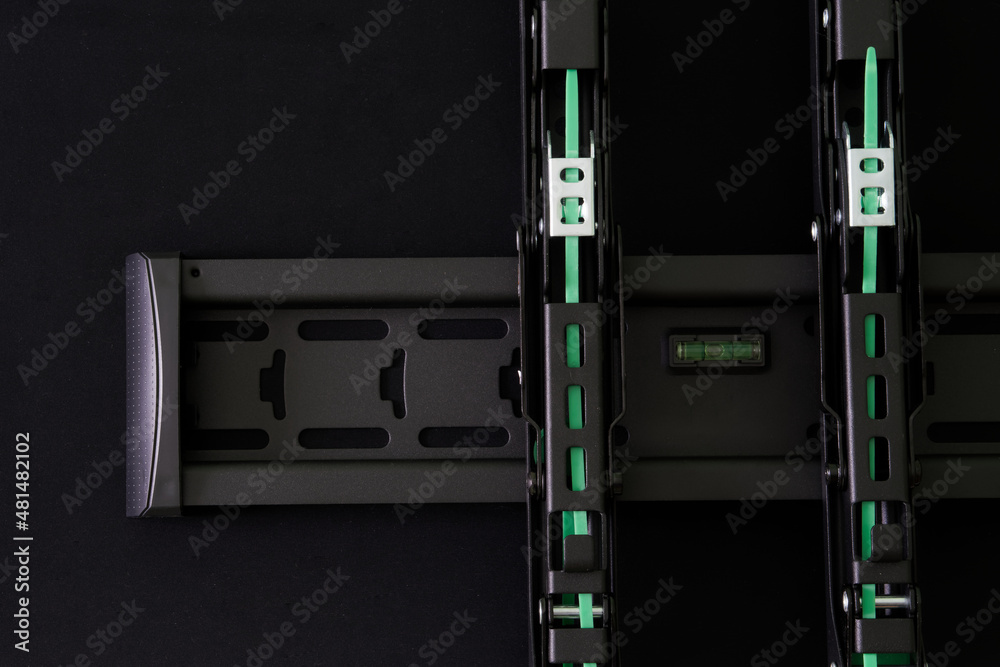 Metal bracket for wall mounting a TV or monitor on a black background Metal bracket for wall mounting a TV or monitor on a black background