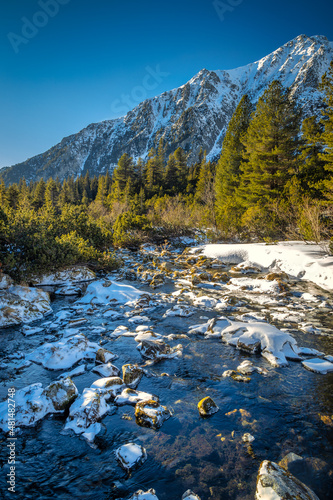 View of the landscape with stream in vallye of snowy mountains. High Tatras National Park, Slovakia, Europe. photo