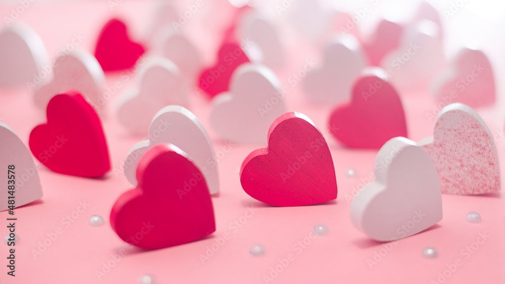 Lots of pink and white hearts on a light pink background. Love concept. Greeting card.Background of different colored wooden hearts.Valentine s day concept