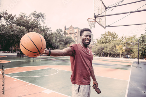 USA, Pennsylvania, Philadelphia, Smiling man with ball at basketball court © Cultura Creative