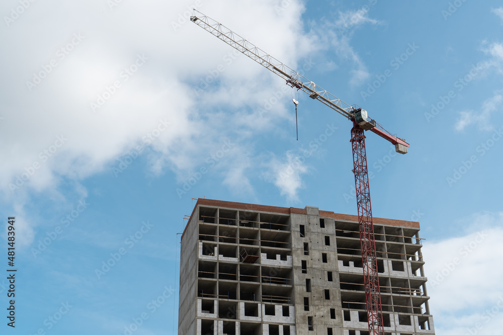 Tower crane lifting concrete panels at construction site during building construction. Tower crane lifting concrete panels at construction site during building construction.