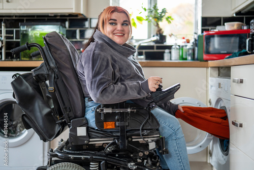 Woman in wheelchair doing laundry