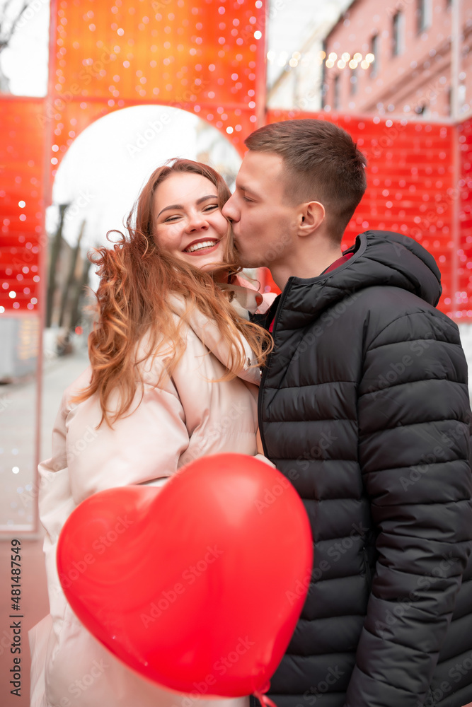 Photo of a couple, with heart-shaped balloons in the city. Concept for valentine's day, gifts, love