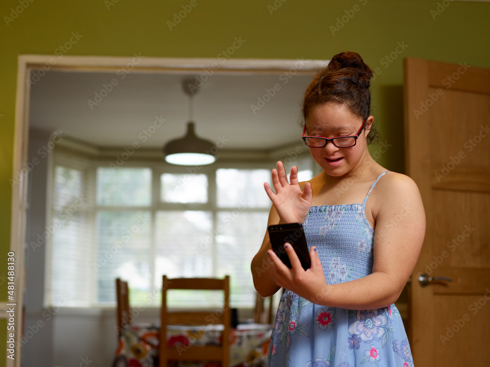 Girl with Down syndrome having video call on phone Girl with Down syndrome having video call on phone