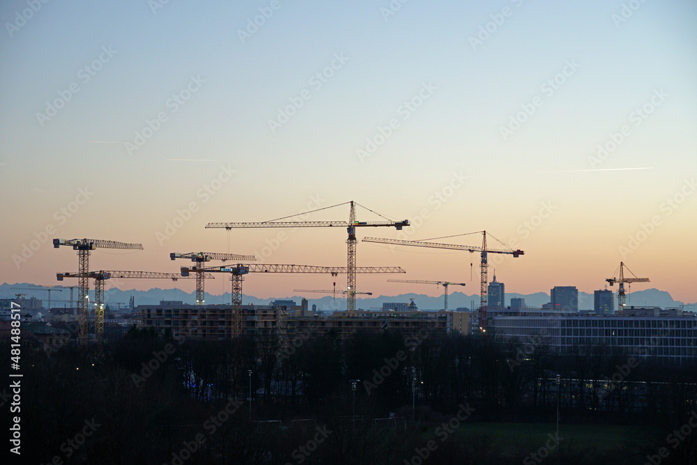 sunset munich with cranes and the alps - obrazy, fototapety, plakaty 