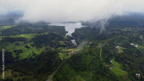 Flight over clouds to mountain lake