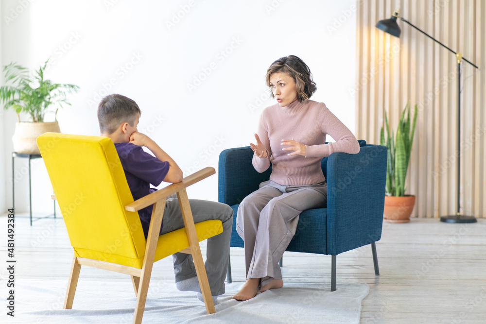 Woman conducts an explanatory conversation with a difficult teenager. School psychologist. Full-length image. Woman conducts an explanatory conversation with a difficult teenager. School psychologist. Full-length image.
