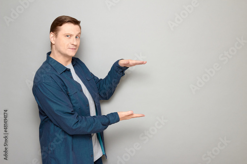 Portrait of happy mature man showing size of something with hands