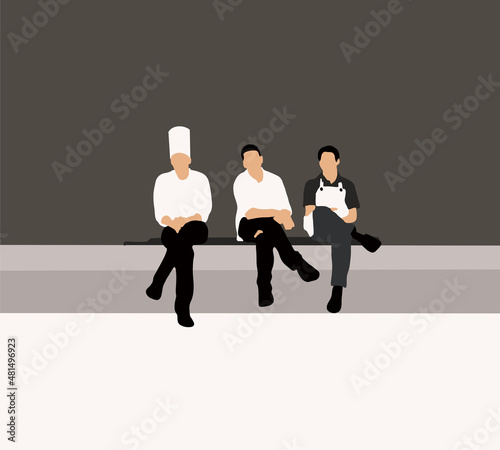 Chefs in uniform with aprons taking a break after hard work at work place copy space. in restaurant kitchen