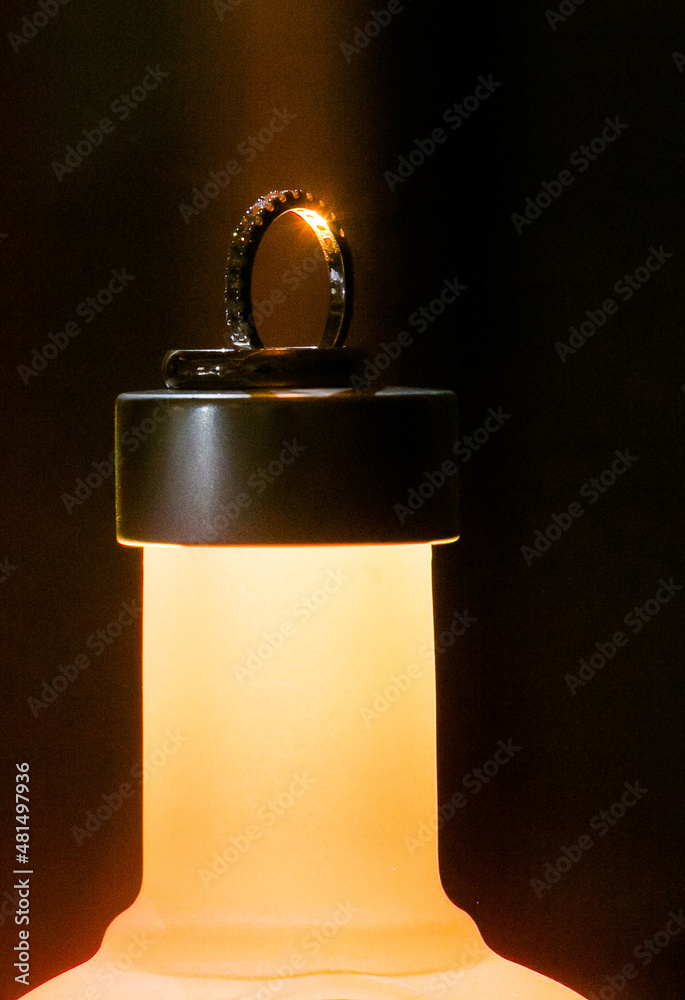 Wedding ring on alcohol bottle with a catch light