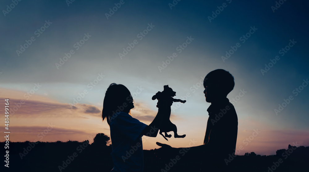 Couple man and woman with a dog staying on outdoor with sunset scenery people romantic relationship and friendship concept.