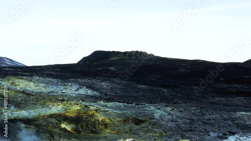 Black solidified lava field with yellow colored sulfur deposit on surface photo