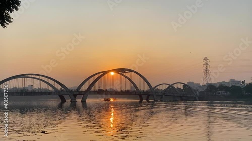 View of a traffic movement on a bridge over a river with a beautiful setting sun in the background in Dhaka, Bangladesh. photo