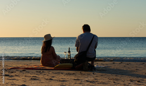 A couple having a glass of wine at sunset on Port Willunga Beach, Fleurieu Peninsula, South Australia. photo