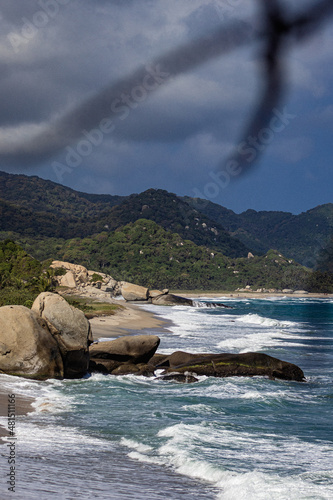 landscape with rocks, beach, mountains and clouds