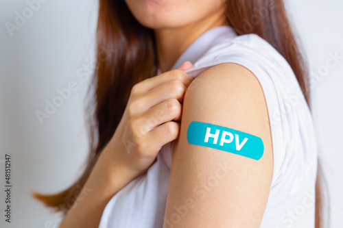 Fototapeta HPV (Human Papillomavirus) Teenager woman showing off an blue bandage after receiving the HPV vaccine