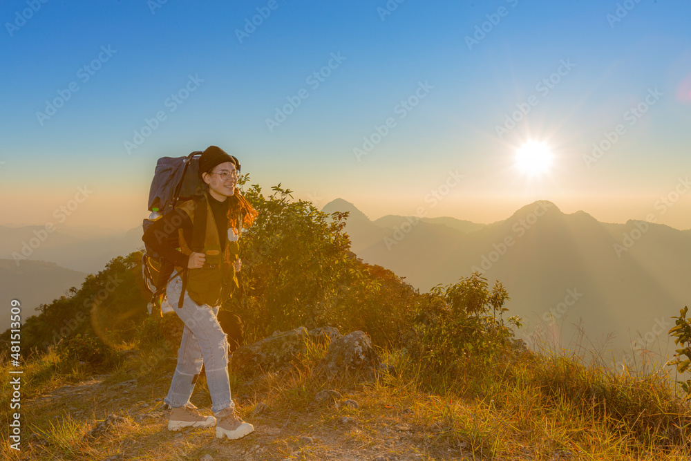 Obraz premium young female tourist carrying luggage at sunset