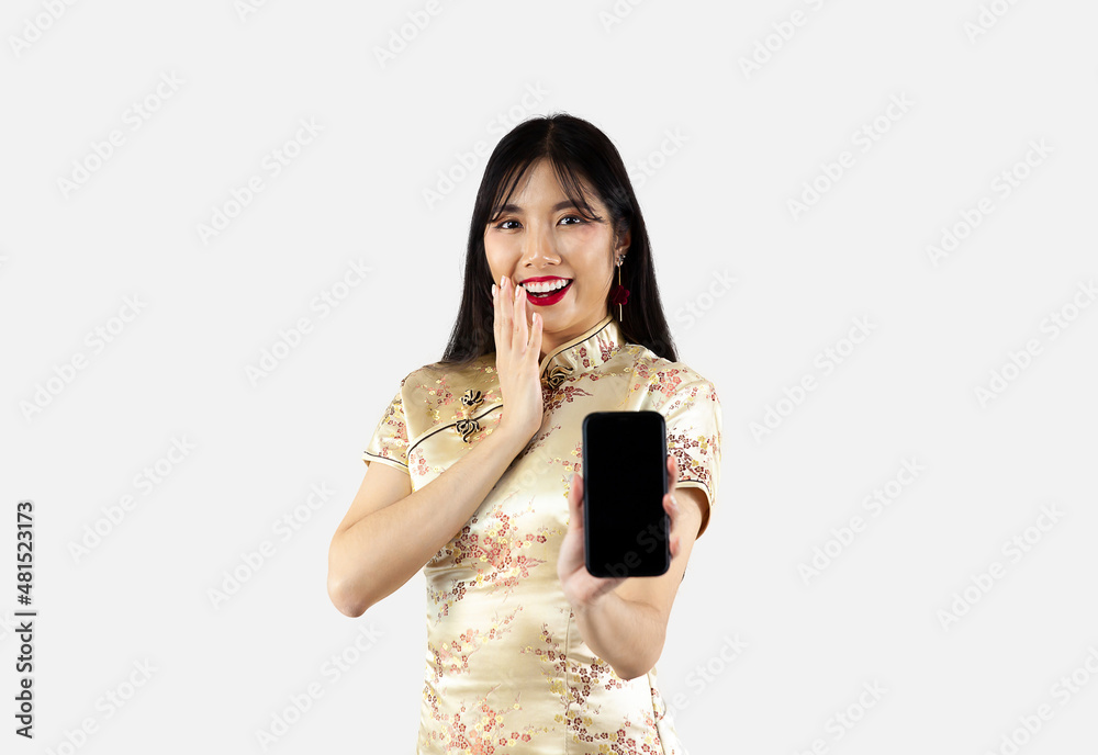 Asian woman in gold traditional oriental costume holding smartphone with black screen on white background. Chinese new year concept Asian woman in gold traditional oriental costume holding smartphone with black screen on white background. Chinese new year concept