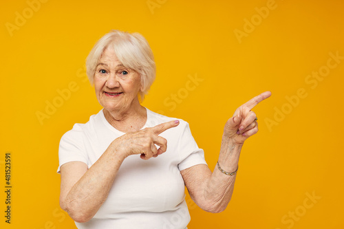 smiling elderly woman in casual t-shirt gestures with his hands cropped view
