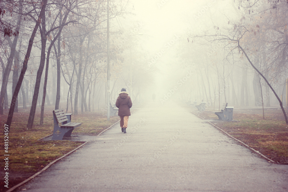Fototapeta premium Woman traveler walks along a foggy road in the early morning. Concept of travel and adventure in Asia.