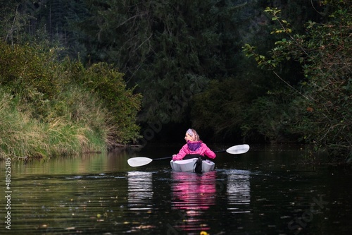 Middle age woman kayaking in a calm water in a foladable kayak. Widgeon Creeek. Maple Ridge. British Columbia. Canada photo