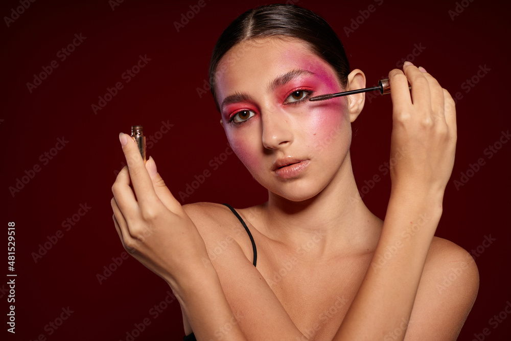 Obraz premium Portrait of beautiful young woman makeup emotions cosmetics hair care mascara pink background unaltered