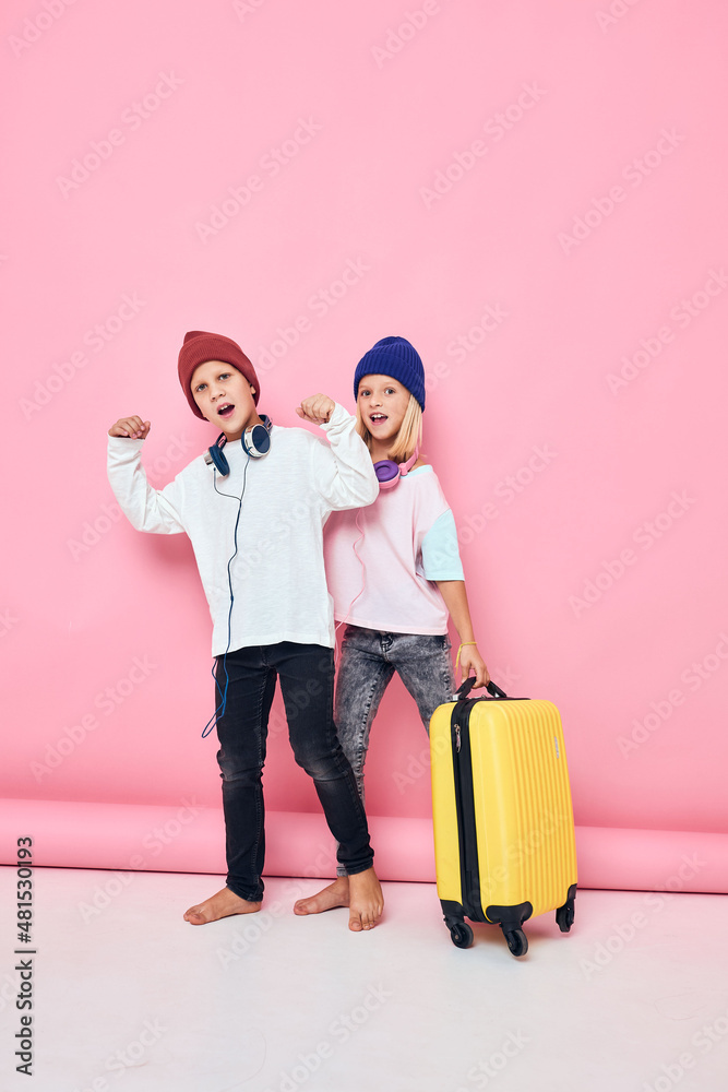 funny little boy and girl yellow suitcase with headphones studio posing funny little boy and girl yellow suitcase with headphones studio posing