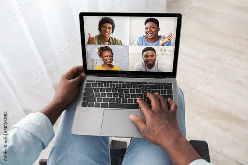 Black man in wheelchair using computer, having online party